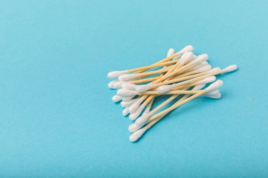 Mavi arka planda pamuk tomurcukları. Çevre dostu malzemeler. Tahta, beyaz bir zeminde pamuk örnekleri. Bambu bezleri ve pamuk çiçekleri. Sıfır atık, plastiksiz yaşam tarzı..