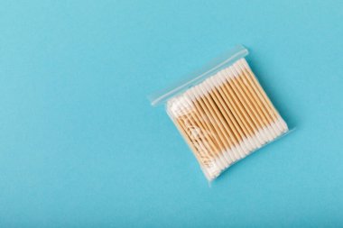 Mavi arka planda pamuk tomurcukları. Çevre dostu malzemeler. Tahta, beyaz bir zeminde pamuk örnekleri. Bambu bezleri ve pamuk çiçekleri. Sıfır atık, plastiksiz yaşam tarzı..