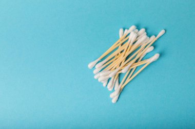 Mavi arka planda pamuk tomurcukları. Çevre dostu malzemeler. Tahta, beyaz bir zeminde pamuk örnekleri. Bambu bezleri ve pamuk çiçekleri. Sıfır atık, plastiksiz yaşam tarzı..