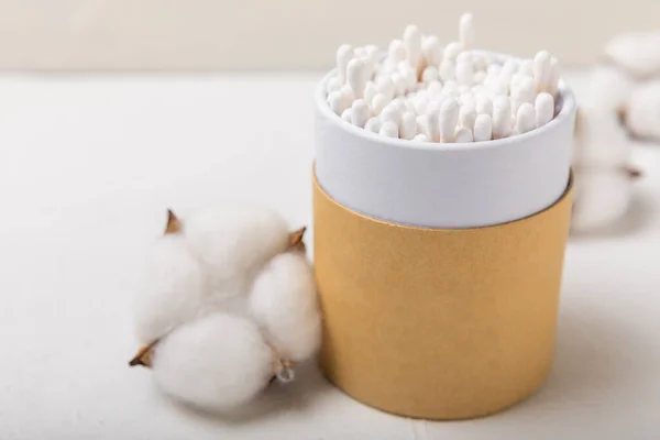 stock image Cotton buds on a light concrete background.Eco-friendly materials. Wooden, cotton swabs on a white background.Bamboo swabs and cotton flowers.Zero waste, plastic free lifestyle concept.Place for text.