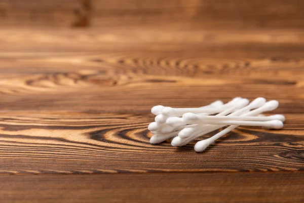 Cotton buds on a brown background. Hygienic cotton sticks and cotton pads on a textural background.ear sticks. Place for text. Place to copy.Closeup.