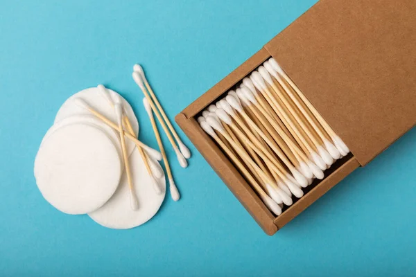 Cotton buds and cotton pads on a blue background.Eco-friendly materials. Wooden, cotton swabs on a white background.Bamboo swabs and cotton flowers.Zero waste, plastic free lifestyle concept.Place for text.