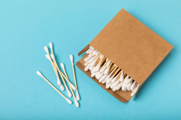 stock image Cotton buds on a blue background.Eco-friendly materials. Wooden, cotton swabs on a white background.Bamboo swabs and cotton flowers.Zero waste, plastic free lifestyle concept.Place for text.