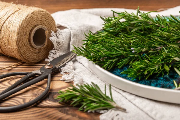 Fresh rosemary herb and vintage scissors on brown wood.Bunch of fresh fragrant rosemary. Spices and herbs for meat and fish. Recipe. Culinary concept.Organic herbs.Place for text. Space for copy. Flat lay.
