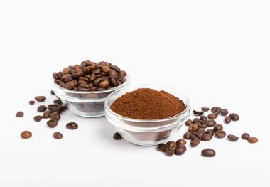 Bowl of ground coffee and beans isolated on a white background.