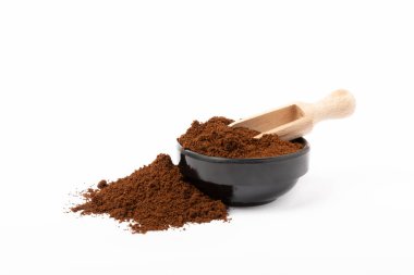 Beyaz arka planda izole edilmiş bir kasede öğütülmüş kahve..