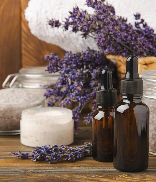 stock image Lavender spa. Essential oils, sea salt, handmade soap, cream and body scrub with lavender flowers on brown texture wood. Natural herbal cosmetics with flowers and lavender aroma.Aromatherapy and relax.