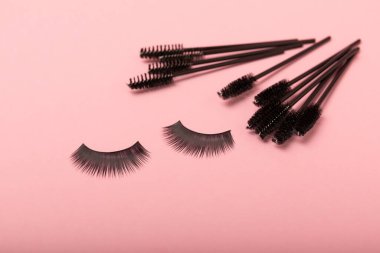 Pembe arka planda kirpik uzatma fırçaları. Uzun ve takma kirpikleri taramak için fırça. Kirpikleri ve kaşları düzeltmek için fırçala.