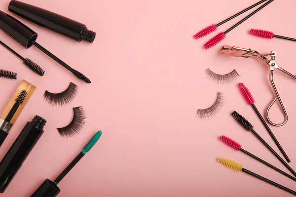 stock image Composition with false eyelashes, mascara and eyelash brushes, eyelash curlers on a pink background. Makeup artist tools. Beauty concept. Makeup. Place for text. Place for copying. Flatley. MOCAP.