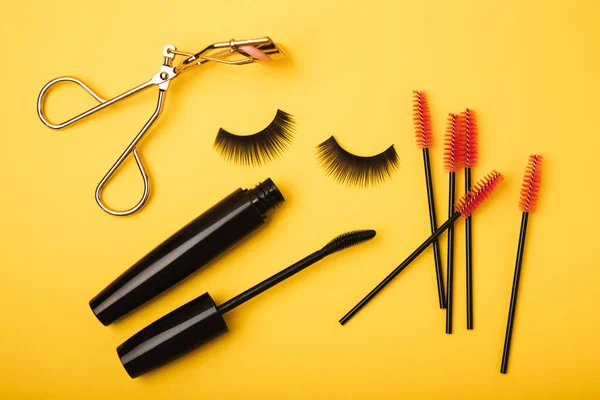 Composition False Eyelashes Mascara Eyelash Brushes Eyelash Curlers Yellow Background — Stock Photo, Image