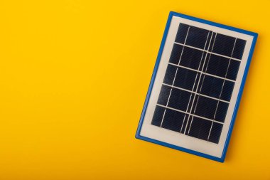 Düz bileşim, sarı arka planda güneş paneli var. Tasarruf ve temiz enerji kavramı. Ekoloji ve sürdürülebilir kalkınma kavramı.