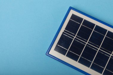 Mavi arka planda güneş paneli olan düz bir bileşim. Tasarruf ve temiz enerji kavramı. Ekoloji ve sürdürülebilir kalkınma kavramı.