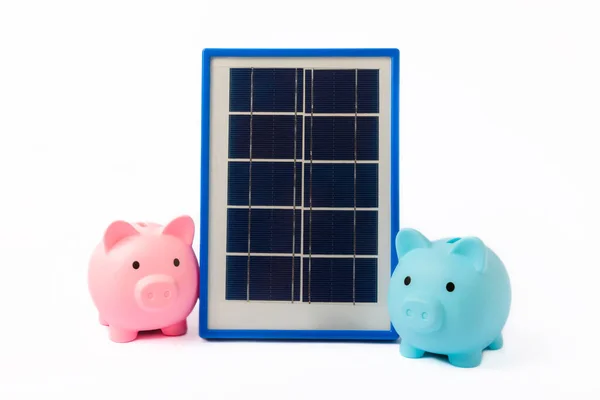 Solar panel and piggy bank on isolated white background. The concept of saving money and clean energy. The concept of ecology and sustainable development.