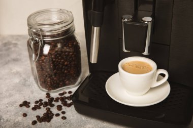 Modern kahve makinesi. Mutfağı yakın çekimde. Bir fincan sıcak kokulu espresso. Sabah kahvesi. Tahta bir masada espresso makinesi. Metin için boşluk. Boşluğu kopyala.