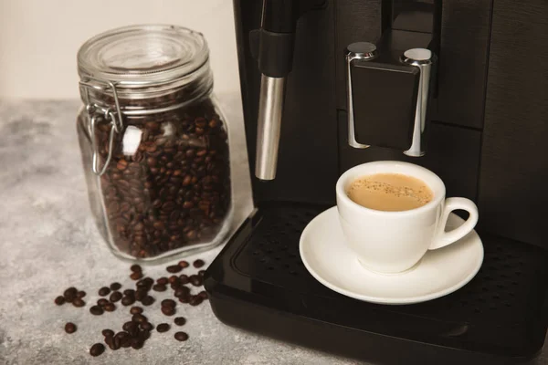 Modern coffee machine with cup in kitchen closeup interior. Cup of hot strong fragrant espresso. Morning coffee. Espresso machine on a wooden table. space for text. copy space.