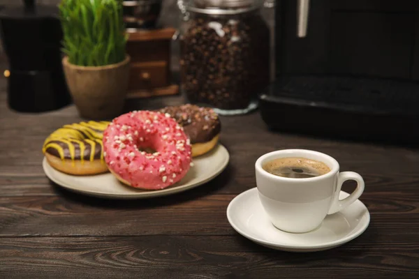 stock image Fragrant delicious espresso coffee with pink strawberry donut, coffee machine on brown texture table. Good morning concept. Morning coffee. Sweet table. Colorful berry buns.Top view.