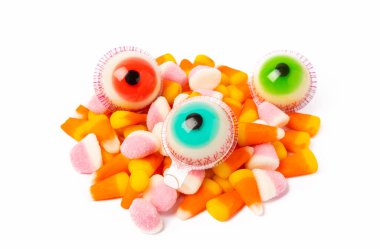 Cadılar Bayramı şekerleme gözü, balkabağı şekerlemesi, beyaz arka planda izole edilmiş mısır şekeri. Cadılar Bayramı 'nda Cadılar Bayramı' nda mısır şekeri ve balkabağı feneriyle birlikte klasik şeker şekeri konsepti..