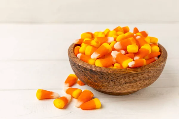 Halloween candy corn on white texture background.Classic white, orange and yellow candy corn sweets for Halloween with.copy space.Halloween holiday concept with candy corn and jack o lantern.