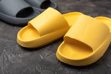 Siyah mermer arka planda ev terlikleri. Kapalı ayakkabılar. Düz çizgi. Rahat etmek için rahat terlikler. Yakın plan. Mesaj için yer. Boşluğu kopyala.