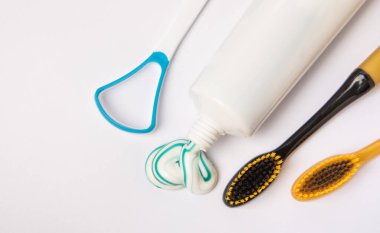 Beyaz arka planda izole edilmiş diş macunu ve diş fırçası tüpü. Yakın plan. Diş plağı ve bakterilerin önlenmesi. Taze nefes. Dişçi konsepti. Ağız bakımı.