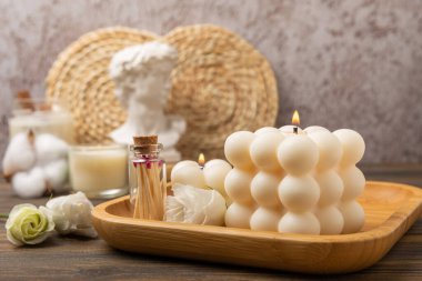 Minimalist bir iç mekanın arka planına karşı samimi bir dekor ve yanan mumlar. Vanilya aromalı modaya uygun balonlu mumlar. Eko soya mumları. Gevşemek için mumlar. Yakın plan. Mesaj için yer. İç mekan. Hygge konsepti.