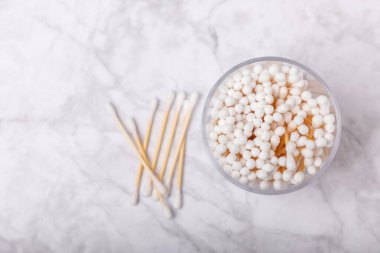 Beyaz mermer arka planda el işi ambalajında pamuk çubukları. Bambu pamuk tomurcukları. Kulakların hijyeni için. Çevre dostu materyaller. Hijyenik pamuk tokaları..