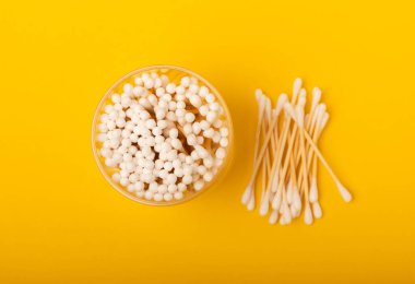 Sarı dokuda pamuk örnekleri. Bambu pamuk tomurcukları. Kulakların hijyeni için. Çevre dostu materyaller. Hijyenik pamuk tokaları..