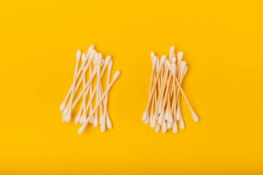 Sarı dokuda pamuk örnekleri. Bambu pamuk tomurcukları. Kulakların hijyeni için. Çevre dostu materyaller. Hijyenik pamuk tokaları..