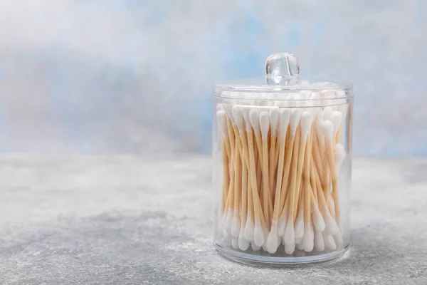 stock image Cotton swabs in craft packaging and holder on a gray cement background. Bamboo cotton buds. Means for hygiene of ears. Eco-friendly materials.Hygienic cotton ear buds.