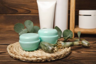 Care cosmetics for face, body and hair on a wooden shelf. A set of cosmetic products shampoo, cream, serum and scrub on a shelf in the bathroom. Foreground. copy space. Beauty concept.