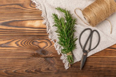 Kahverengi dokuya sahip taze biberiye dalları. Baharatlı baharatlar. Et ve balık çeşnisi. Yemek pişirme konsepti. Fiş ver. Yakın plan. metin için yer.