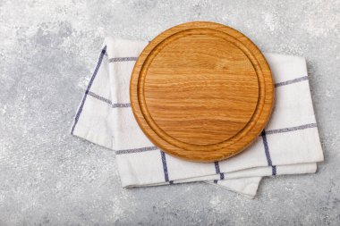 Ahşap mutfak masasında havlunun üzerinde tahta kesme tahtası. Arka planda pizza tahtası ve mutfak havlusu var. Menü yemek kartı ya da yemek tarifleri arka plan kavramı. MOCKUP Tasarım. Metin için yer, kopyalama alanı.