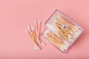 Çevre dostu pamuk çubuğu, pembe arka planda bambu pamuk tomurcukları. Plastiksiz atık kozmetik ürünleri. Eko mallar. Hijyen. Mesaj için yer. Kopyalanacak yer.