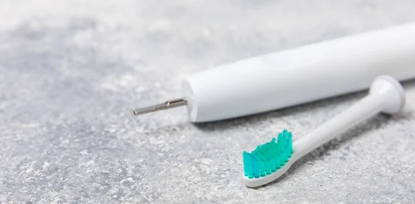 Electric toothbrush on a cement background. Smart electric toothbrush. It is charged from a power bank and controlled from a smartphone. Modern technologies for health. healthy teeth.Dentistry concept.
