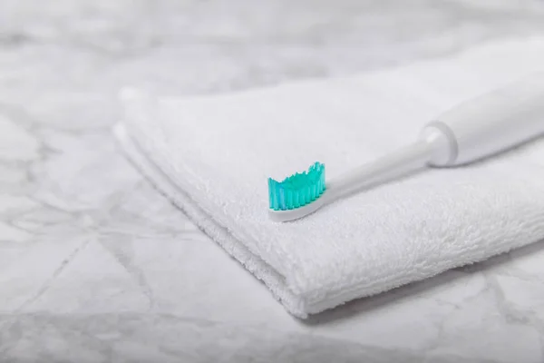 Electric toothbrush and toothpaste on a white towel on the background of the bathroom. Smart electric toothbrush. healthy teeth.Dentistry concept.