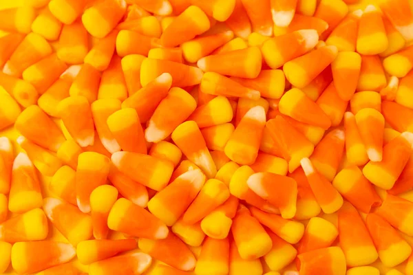 Halloween candy corn on texture background.Classic white, orange and yellow candy corn sweets for Halloween with.copy space.Halloween holiday concept with candy corn and jack o lantern.copy space