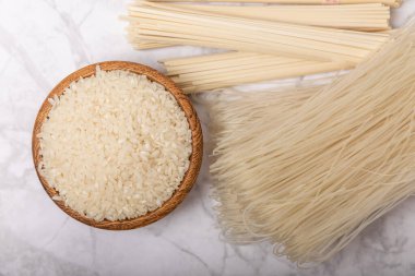 pirinç eriştesi. Beyaz mermer arka planda pirinç unlu erişte. Funchoza. Kuru pirinç eriştesi. Yakın çekim. Uzayı kopyala. Metin için yer.