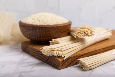 pirinç eriştesi. Beyaz mermer arka planda pirinç unlu erişte. Funchoza. Kuru pirinç eriştesi. Yakın çekim. Uzayı kopyala. Metin için yer.