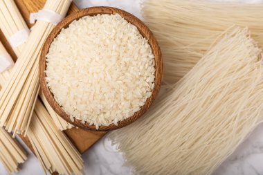 pirinç eriştesi. Beyaz mermer arka planda pirinç unlu erişte. Funchoza. Kuru pirinç eriştesi. Yakın çekim. Uzayı kopyala. Metin için yer.