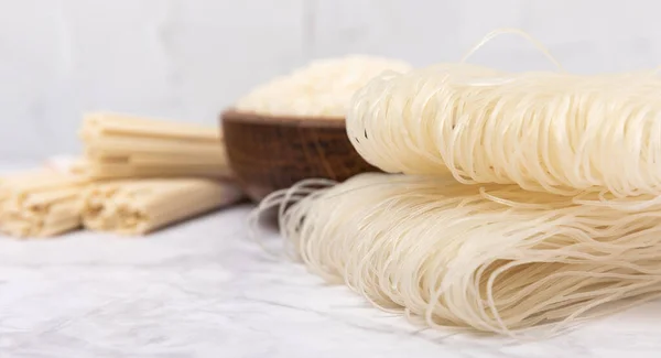 stock image rice noodles. Noodles with rice flour on a white marble background. Funchoza. Dry rice noodles.Close-up.Copy space. Place for text.