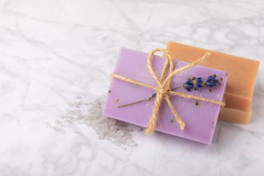 Lavanta spreyi, deniz tuzu, lavanta çiçekleri, aroma mumu, vücut kremi ve el yapımı sabun. Mermer arka planda lavanta çiçekleri olan doğal bitkisel kozmetik ürünleri. Rahatlayın. Güzellik tedavileri..