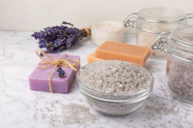 Lavanta spreyi, deniz tuzu, lavanta çiçekleri, aroma mumu, vücut kremi ve el yapımı sabun. Mermer arka planda lavanta çiçekleri olan doğal bitkisel kozmetik ürünleri. Rahatlayın. Güzellik tedavileri..