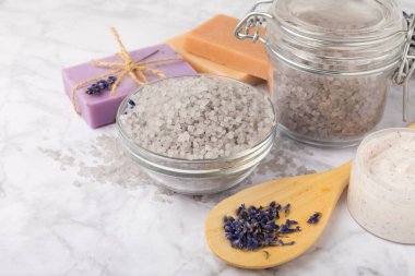 Lavanta spreyi, deniz tuzu, lavanta çiçekleri, aroma mumu, vücut kremi ve el yapımı sabun. Mermer arka planda lavanta çiçekleri olan doğal bitkisel kozmetik ürünleri. Rahatlayın. Güzellik tedavileri..