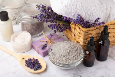 Lavanta spreyi, deniz tuzu, lavanta çiçekleri, aroma mumu, vücut kremi ve el yapımı sabun. Mermer arka planda lavanta çiçekleri olan doğal bitkisel kozmetik ürünleri. Rahatlayın. Güzellik tedavileri..