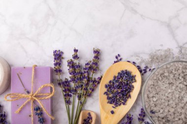 Lavanta spreyi, deniz tuzu, lavanta çiçekleri, aroma mumu, vücut kremi ve el yapımı sabun. Mermer arka planda lavanta çiçekleri olan doğal bitkisel kozmetik ürünleri. Rahatlayın. Güzellik tedavileri..
