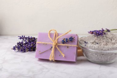 Lavanta spreyi, deniz tuzu, lavanta çiçekleri, aroma mumu, vücut kremi ve el yapımı sabun. Mermer arka planda lavanta çiçekleri olan doğal bitkisel kozmetik ürünleri. Rahatlayın. Güzellik tedavileri..