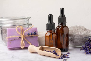 Lavanta spreyi, deniz tuzu, lavanta çiçekleri, aroma mumu, vücut kremi ve el yapımı sabun. Mermer arka planda lavanta çiçekleri olan doğal bitkisel kozmetik ürünleri. Rahatlayın. Güzellik tedavileri..