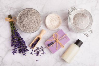 Lavanta spreyi, deniz tuzu, lavanta çiçekleri, aroma mumu, vücut kremi ve el yapımı sabun. Mermer arka planda lavanta çiçekleri olan doğal bitkisel kozmetik ürünleri. Rahatlayın. Güzellik tedavileri..