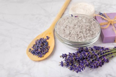 Lavanta spreyi, deniz tuzu, lavanta çiçekleri, aroma mumu, vücut kremi ve el yapımı sabun. Mermer arka planda lavanta çiçekleri olan doğal bitkisel kozmetik ürünleri. Rahatlayın. Güzellik tedavileri..