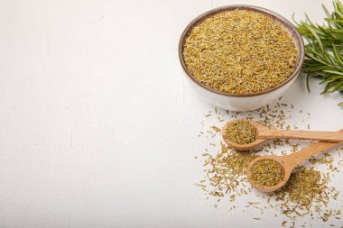 Kasede kurutulmuş biberiye ve beyaz ahşap arka planda taze biberiye dalları. Et ve balık pişirmek için baharatlı baharatlar. Yemek tarifi. Taze biberiye. Metin için yer, kopyalamak için yer.